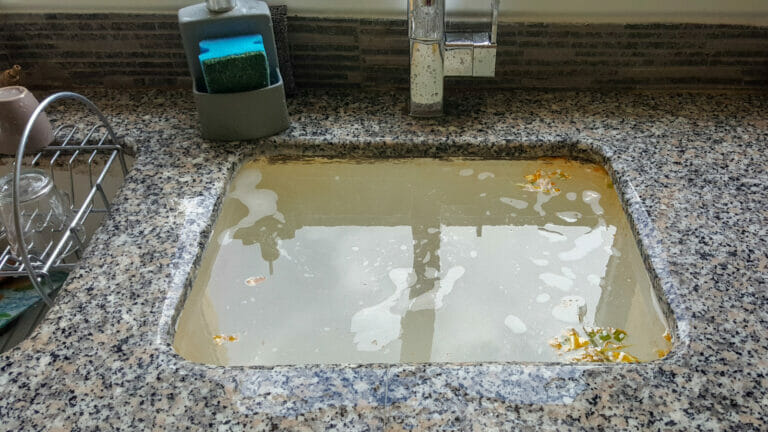 An image illustrating a sink filled with water due to a clog, symbolizing the need for emergency drain cleaning services.