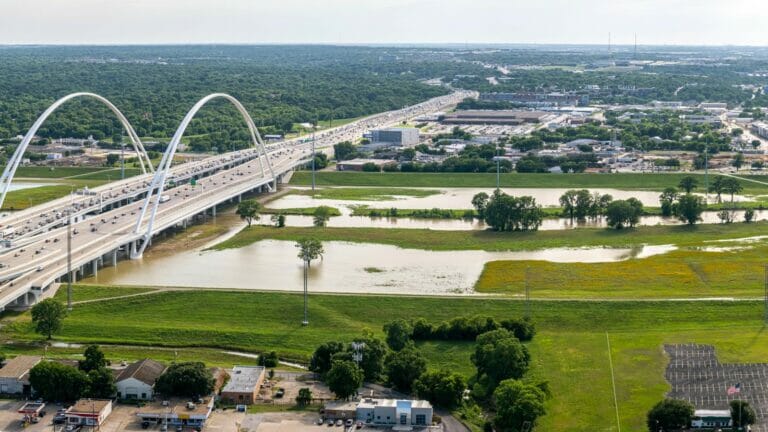 A dramatic image capturing the June flooding of the Trinity River in Dallas, Texas, showcasing the powerful impact of extreme weather conditions on the local landscape.