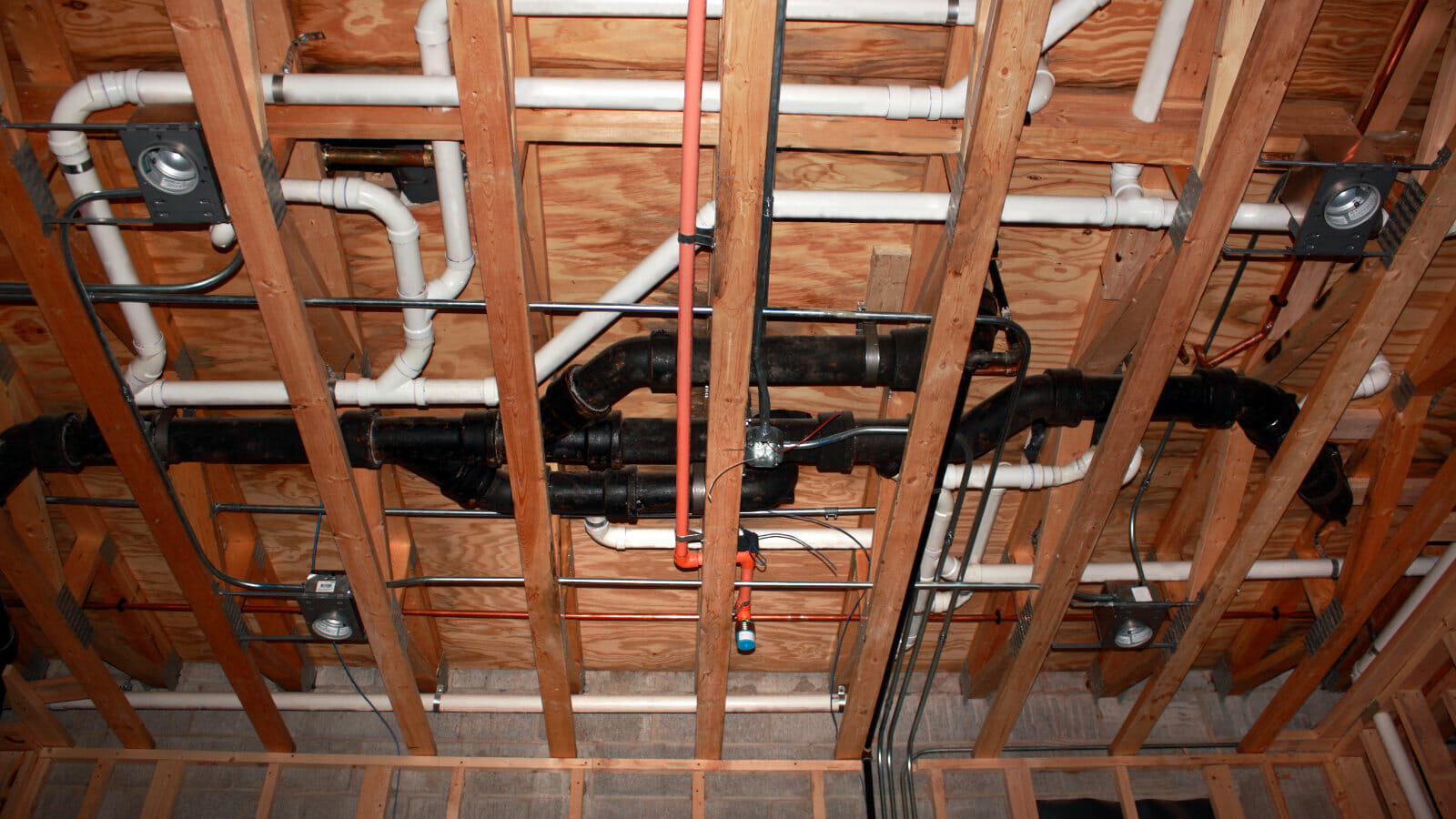 Close-up of plumbing installations at a new residential construction site, emphasizing the focus on quality plumbing for new homes.