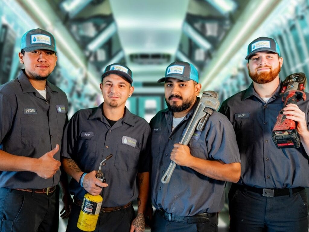 Team of Intown Plumbing technicians posing with plumbing tools
